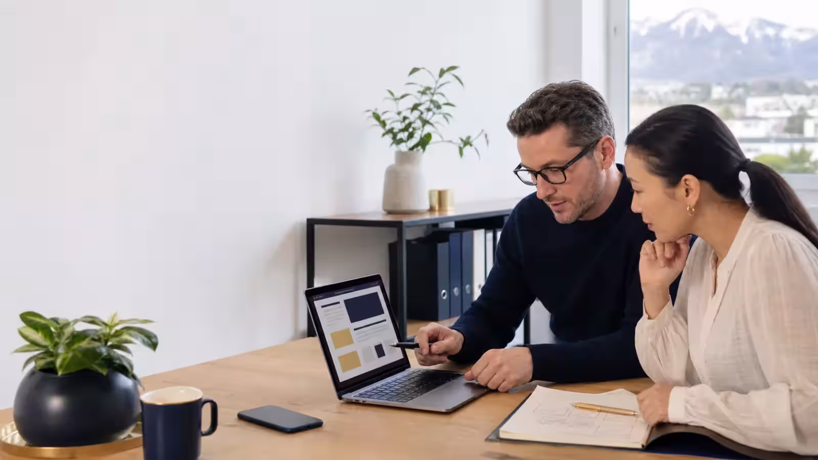 Dirigeante de PME suisse et consultant examinant des pages de services sur un ordinateur portable